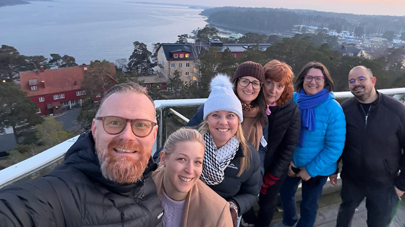 Sex personer står på en plats med utsikt.